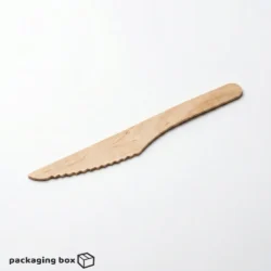 Hand cutting chocolate cake with a birchwood wooden serrated knife — eco-friendly disposable cutlery by PackagingBox.pk