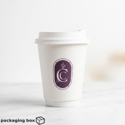 Three white 12oz custom screen printed coffee cups with brand logos and black and white lids on marble surface