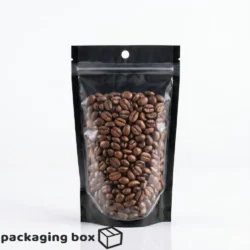 Front transparent back black aluminium standup pouch filled with coffee beans grains and dry fruits
