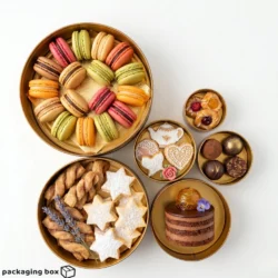 Golden round tin box filled with cookies, macarons and chocolates