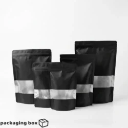 Black Kraft Standup Pouch with clear window showing multiple sizes of matte black resealable zip lock bags by Packaging Box Pakistan