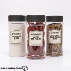 Three clear round plastic jars with black lids filled with fine granulated sugar whole dry red chilies and authentic whole garam masala blend with packaging pk premium labels