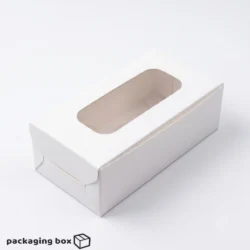 Two 2-piece brownie boxes side by side β kraft brown and white β each with a clear rectangular window showing fudgy brownies inside
