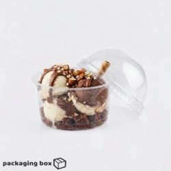 Clear disposable dessert cup with lid filled with caramel ice cream scoops, nuts, chocolate and cookie crumble β available at PackagingBox.pk