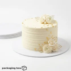 White Cake Board under a single-tier ivory buttercream cake with white roses and gold leaf decorations by Packaging Box Pakistan